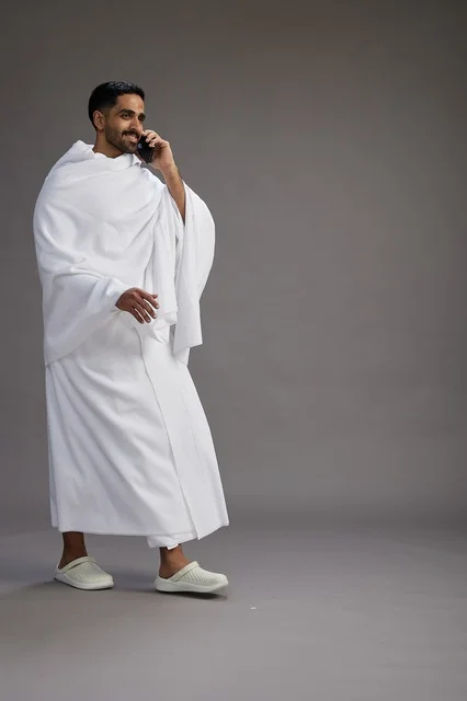 بورتريه لرجل سعودي بملابس الإحرام يجري مكالمة هاتفية عبر الهاتف المحمول, الاستعداد لاداء مناسك الحج والعمره, الجسم بالطول الكامل , خلفيه رماديه بورتريه لرجل سعودي بملابس الإحرام يجري مكالمة هاتفية عبر الهاتف المحمول, الاستعداد لاداء مناسك الحج والعمره, الجسم بالطول الكامل , خلفيه رماديه