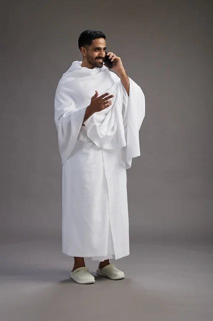 بورتريه لرجل سعودي بملابس الإحرام يجري مكالمة هاتفية عبر الهاتف المحمول, الاستعداد لاداء مناسك الحج والعمره, الجسم بالطول الكامل , خلفيه رماديه بورتريه لرجل سعودي بملابس الإحرام يجري مكالمة هاتفية عبر الهاتف المحمول, الاستعداد لاداء مناسك الحج والعمره, الجسم بالطول الكامل , خلفيه رماديه