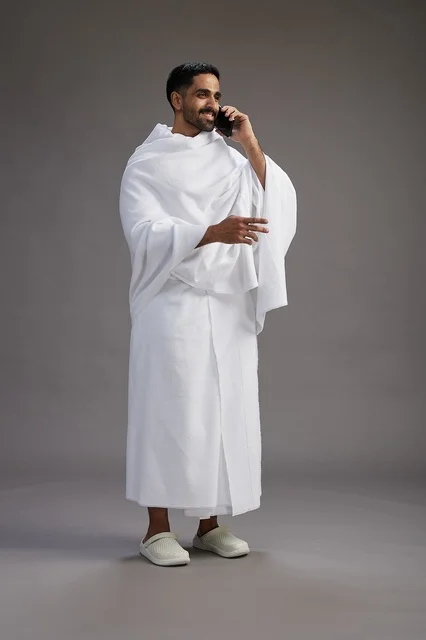 بورتريه لرجل سعودي بملابس الإحرام يجري مكالمة هاتفية عبر الهاتف المحمول, الاستعداد لاداء مناسك الحج والعمره, الجسم بالطول الكامل , خلفيه رماديه بورتريه لرجل سعودي بملابس الإحرام يجري مكالمة هاتفية عبر الهاتف المحمول, الاستعداد لاداء مناسك الحج والعمره, الجسم بالطول الكامل , خلفيه رماديه