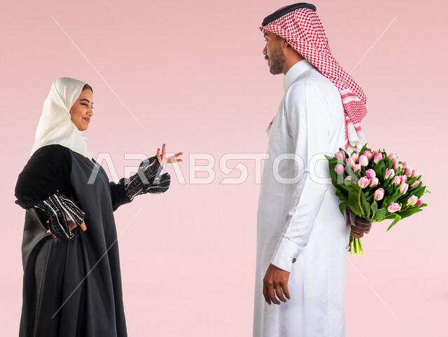 بورتريه زوجان سعيدان يحتفلان بعيد الحب , الزوج يقدم لزوجته باقة ورد , الزوجة تعبر بإيماءات وجه ويدين تدل على الدهشة والفرح , عيد الأم , يوم الفلنتاين , أعياد ومناسبات , عيد الميلاد , خلفية وردية .