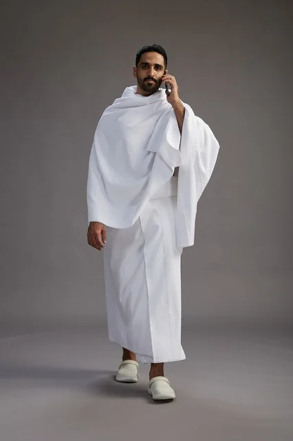بورتريه لرجل سعودي بملابس الإحرام يجري مكالمة هاتفية عبر الهاتف المحمول, الاستعداد لاداء مناسك الحج والعمره, الجسم بالطول الكامل , خلفيه رماديه بورتريه لرجل سعودي بملابس الإحرام يجري مكالمة هاتفية عبر الهاتف المحمول, الاستعداد لاداء مناسك الحج والعمره, الجسم بالطول الكامل , خلفيه رماديه