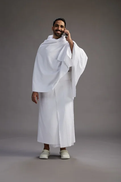 بورتريه لرجل سعودي بملابس الإحرام يجري مكالمة هاتفية عبر الهاتف المحمول, الاستعداد لاداء مناسك الحج والعمره, الجسم بالطول الكامل , خلفيه رماديه بورتريه لرجل سعودي بملابس الإحرام يجري مكالمة هاتفية عبر الهاتف المحمول, الاستعداد لاداء مناسك الحج والعمره, الجسم بالطول الكامل , خلفيه رماديه