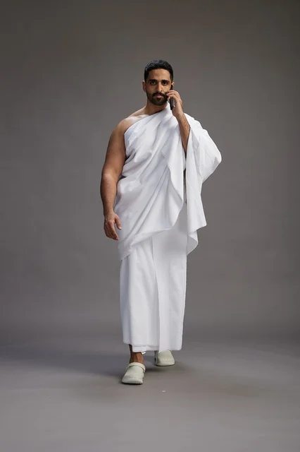 بورتريه لرجل سعودي بملابس الإحرام يجري مكالمة هاتفية عبر الهاتف المحمول, الاستعداد لاداء مناسك الحج والعمره, الجسم بالطول الكامل , خلفيه رماديه بورتريه لرجل سعودي بملابس الإحرام يجري مكالمة هاتفية عبر الهاتف المحمول, الاستعداد لاداء مناسك الحج والعمره, الجسم بالطول الكامل , خلفيه رماديه