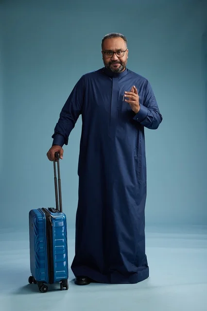 بورتيه لرجل  عربي سعودي  خليجي بثوب أزرق واقف مع حقيبة سفر, الاستعداد للسفر  والسياحه, الجسم بالطول الكامل, خلفيه زرقاء