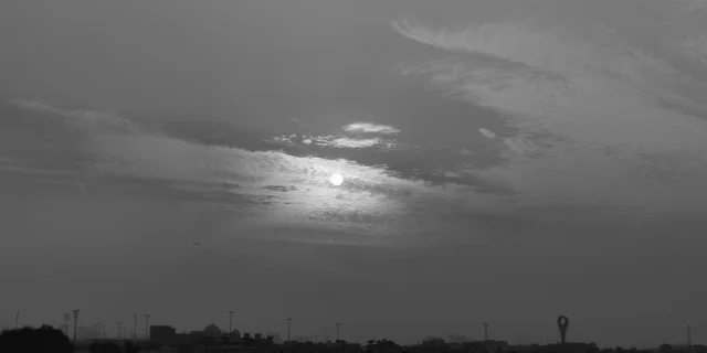 صورة بالابيض والاسود للمناظر الطبيعية على شاطئ الممزر ، معالم مشهورة في الامارات العربية المتحدة ،وجهة سياحية لجذب واستقطاب السياح،  الواجهة البحرية الساحلية في مدينة دبي, الغيوم والسحب في السماء وقت غروب الشمس