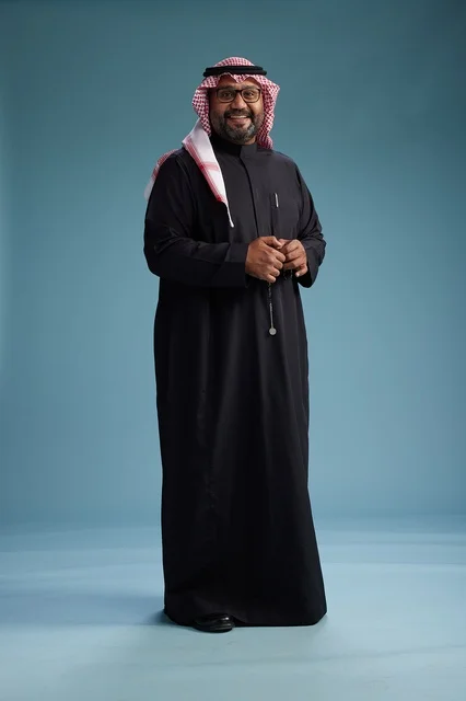 رجل سعودي مبتسم يرتدي ثوب أسود مع شماغ وعقال, الوقوف بثقه لكامل الجسم, خلفيه زرقاء رجل سعودي مبتسم يرتدي ثوب أسود مع شماغ وعقال, الوقوف بثقه لكامل الجسم, خلفيه زرقاء