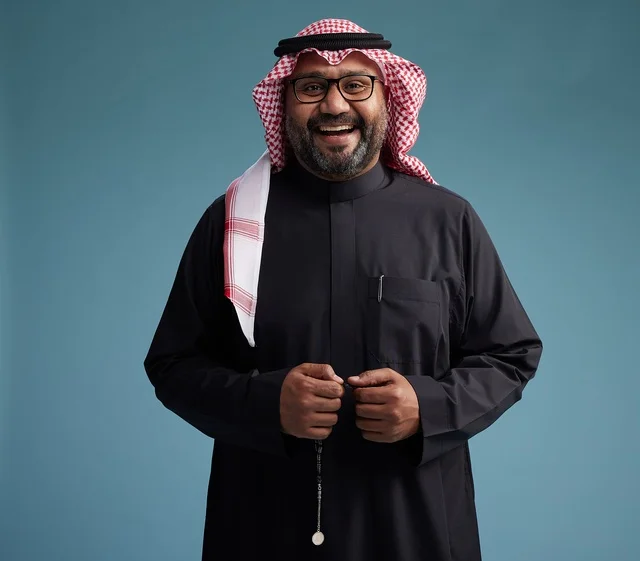 A smiling Saudi man wearing a black thobe with a shemagh and agal, with various hand gestures and movements, against a blue background.
