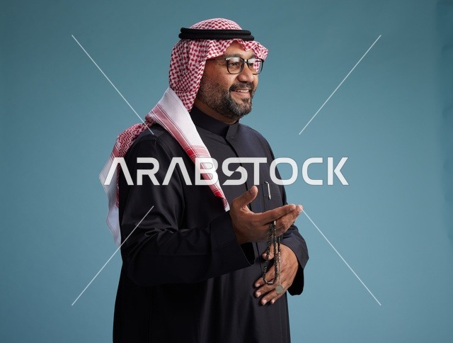 رجل سعودي مبتسم يرتدي ثوب أسود مع شماغ وعقال, ايماءات وحركات يد متنوعه, خلفيه زرقاء