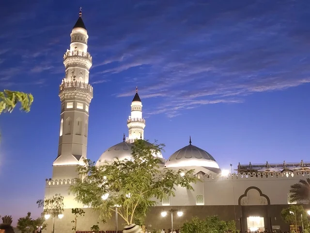 The minarets and illuminated domes at night are landmarks and sacred religious places in the Kingdom of Saudi Arabia, calling Muslims to perform prayers and draw closer to God Almighty. The Quba Mosque in Medina after the Fajr prayer, the architectural engineering art, and Islamic decorations in a modern style.