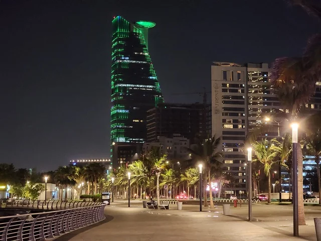 The Kingdom Tower in Riyadh, Saudi Arabia, illuminated in green at night, events and celebrations of the Saudi National Day 92, famous landmarks of Riyadh, tourism in Saudi Arabia.