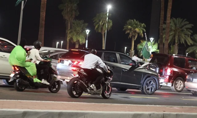 Traffic and cars in Riyadh, the Kingdom Tower in Saudi Arabia illuminated in green at night, events and celebrations of the Saudi National Day 92, famous landmarks of Riyadh, tourism in Saudi Arabia.