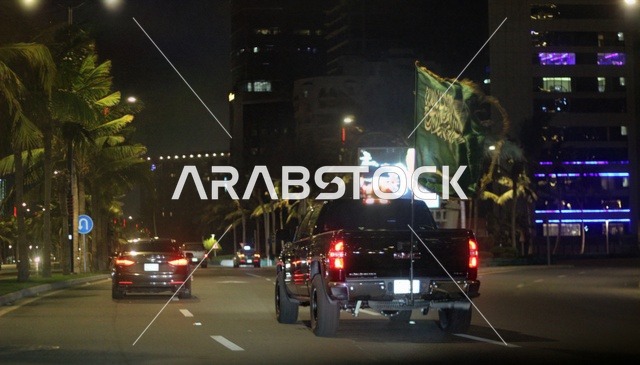 Traffic and cars in Riyadh, the Kingdom Tower in Saudi Arabia illuminated in green at night, events and celebrations of the Saudi National Day 92, famous landmarks of Riyadh, tourism in Saudi Arabia.