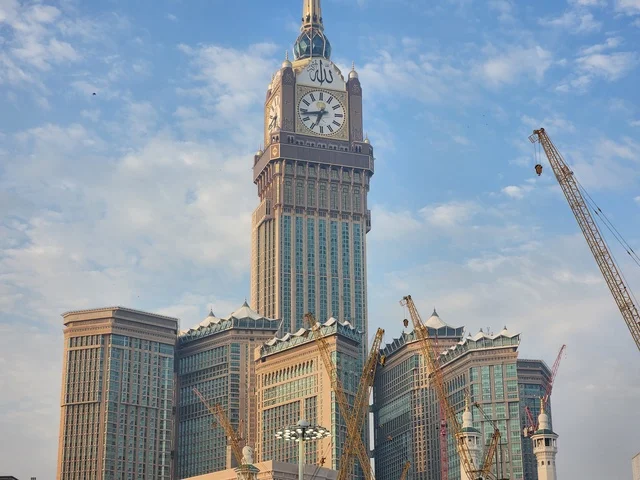 The growth and urban development of the towers and skyscrapers surrounding the Holy Mosque, the Royal Clock Tower building in Mecca, sacred Islamic religious landmarks, and modern architectural engineering art in the Kingdom of Saudi Arabia.