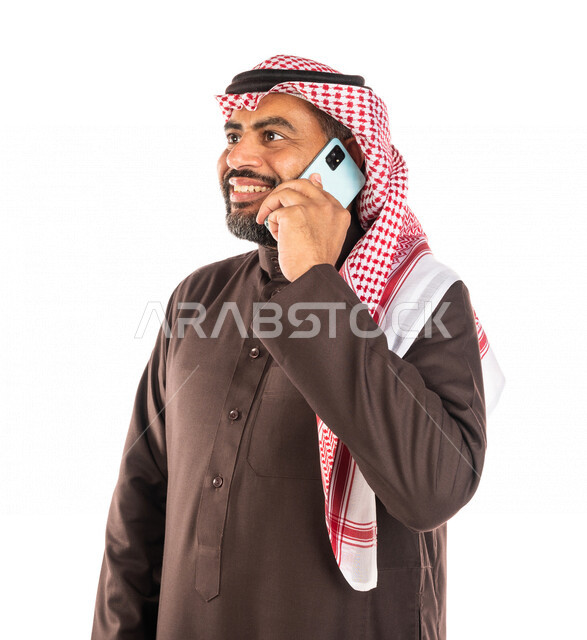 بورتريه لرجل عربي خليجي سعودي يجري اتصال من خلال الهاتف المحمول، اجراء مكالمة هاتفية، إتصال و تعارف، علاقات إجتماعية، ايماءات وجه مبتسمة، خلفية بيضاء