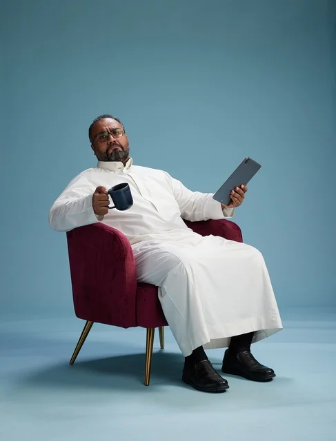 A Saudi man in traditional attire holding a tablet, using the mobile tablet, various gestures and movements, blue background.
