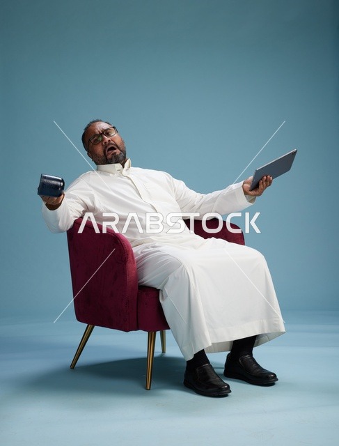 رجل سعودي بالزي التقليدي يحمل جهاز لوحي, استخدام التابليت المحمول, ايماءات وحركات متنوعه, خلفيه زرقاء