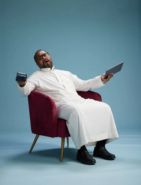 A Saudi man in traditional attire holding a tablet, using the mobile tablet, various gestures and movements, blue background.