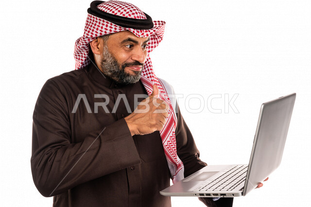 Portrait of a Saudi Arabian Gulf man holding a laptop in his hand, making online video calls, social communication, conversations and chatting, communicating with friends, remote business meeting, video call, live video broadcasting, white background