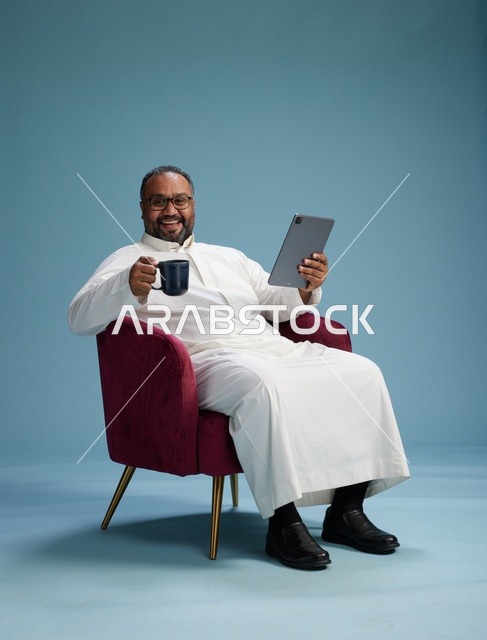 A Saudi man in traditional attire holding a tablet, using the mobile tablet, various gestures and movements, blue background.