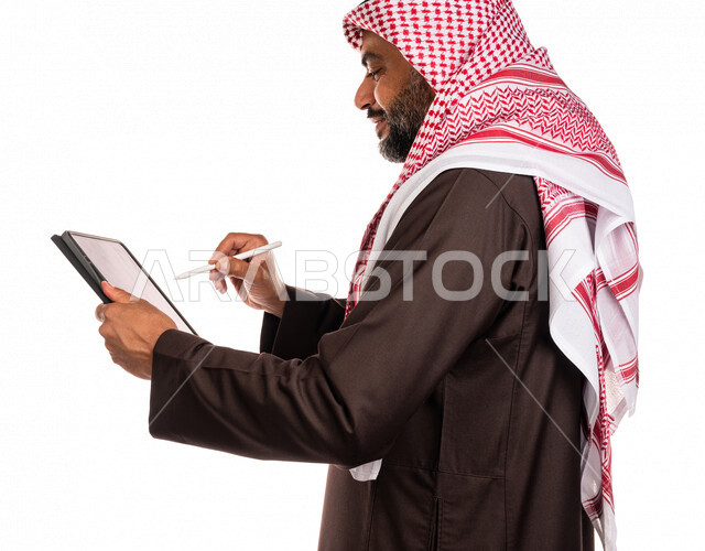 بورتريه لرجل عربي خليجي سعودي يستخدم التابليت المحمول، التسويق الإلكتروني، العمل عن بعد، استخدام قلم التابليت لتدوين الملاحظات، استخدام تقنيات حديثة، خلفية بيضاء