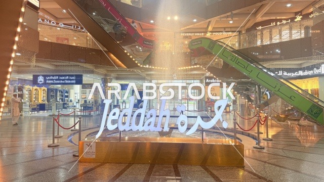 لافتة جدة مضاءة ومزخرفة في مركز المحمل للتسوق في منطقة البلد التاريخية في جدة، وجهة شهيرة للحجاج والزوار، التصميم الداخلي المميز يمزج بين الزخارف التقليدية والتصميم المعاصر