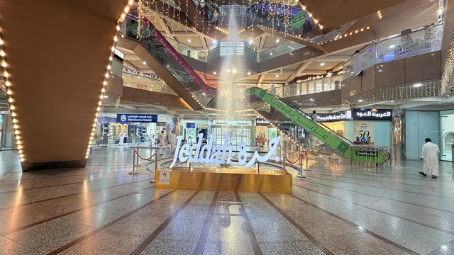 The illuminated and decorated Jeddah sign is located in the Al-Mahmal shopping center in the historic Al-Balad area of Jeddah, a popular destination for pilgrims and visitors. The distinctive interior design blends traditional decorations with contemporary design.