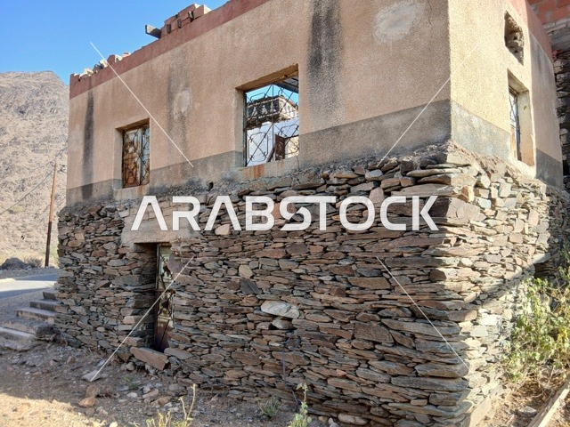 البيوت الحجرية القديمة على الجبال في منطقة الباحة في قرية ذي العين الأثرية جنوب المملكة العربية السعودية، المعالم السياحية التاريخية المشهورة، الأشجار والنباتات الخضراء المحيطة بالقرية على المرتفعات والقمم الجبلية