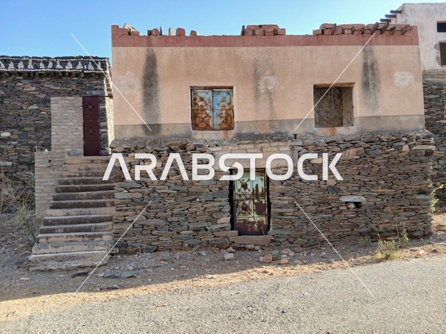 البيوت الحجرية القديمة على الجبال في منطقة الباحة في قرية ذي العين الأثرية جنوب المملكة العربية السعودية، المعالم السياحية التاريخية المشهورة، الأشجار والنباتات الخضراء المحيطة بالقرية على المرتفعات والقمم الجبلية