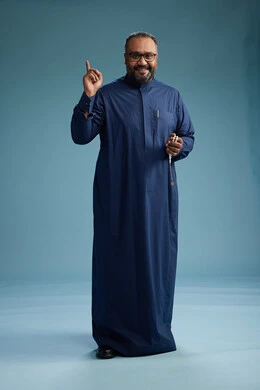 A portrait of a Saudi man standing wearing a navy blue thobe, making various gestures and movements, standing full body, with a blue background.