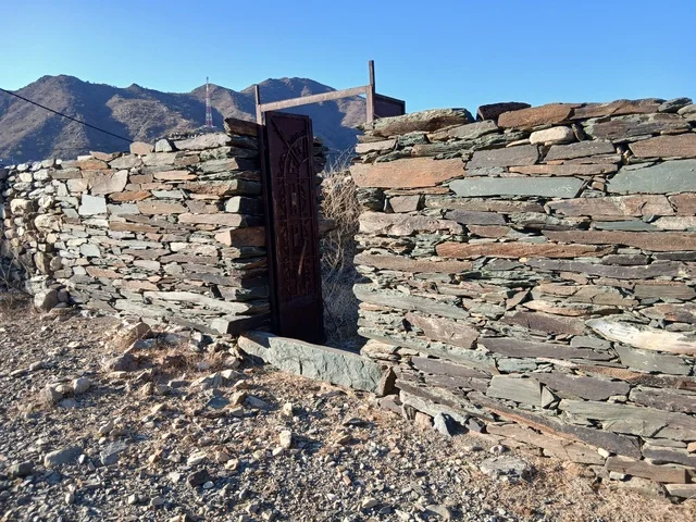 المعالم السياحية التاريخية المشهورة،  البيوت الحجرية القديمة على الجبال في منطقة الباحة في قرية ذي العين الأثرية جنوب المملكة العربية السعودية، الأشجار والنباتات الخضراء المحيطة بالقرية على المرتفعات والقمم الجبلية