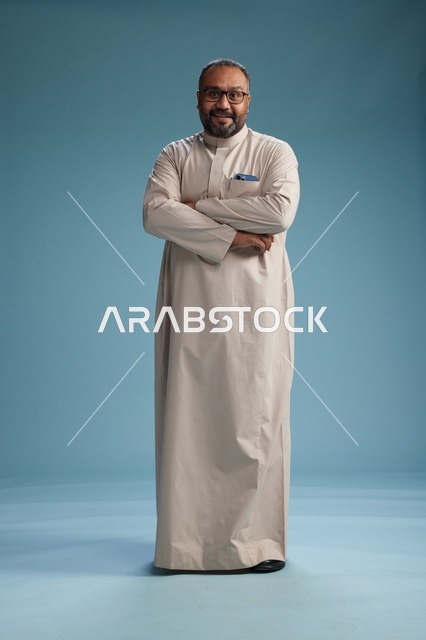 رجل سعودي مبتسم يرتدي ثوب بيج بايماءات وحركات يد متنوعه, كامل الجسم, خلفيه زرقاء