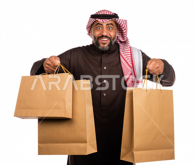بورتريه لرجل عربي خليجي سعودي يحمل مشترياته، العوده من السوق، متعة التسوق، شراء الأغراض الضروريه، التصفيات والخصومات، الجمعة السوداء، الجمعة البيضاء، الحسومات والتنزيلات، رجل سعودي يحمل اكياس التسوق، خلفية بيضاء