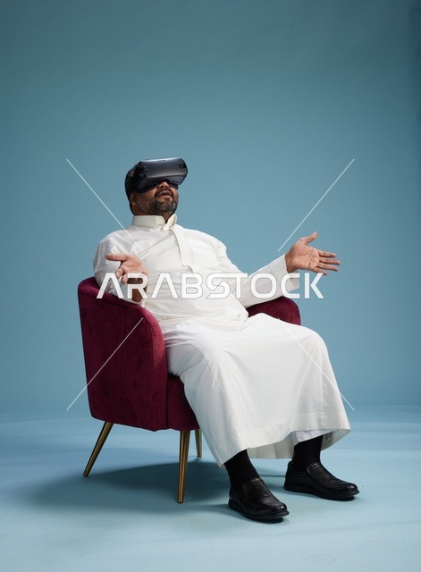 رجل سعودي بالزي التقليدي يخوض تجربة واقع افتراضي, مشاهدة افلام الفي ار, خلفيه زرقاء