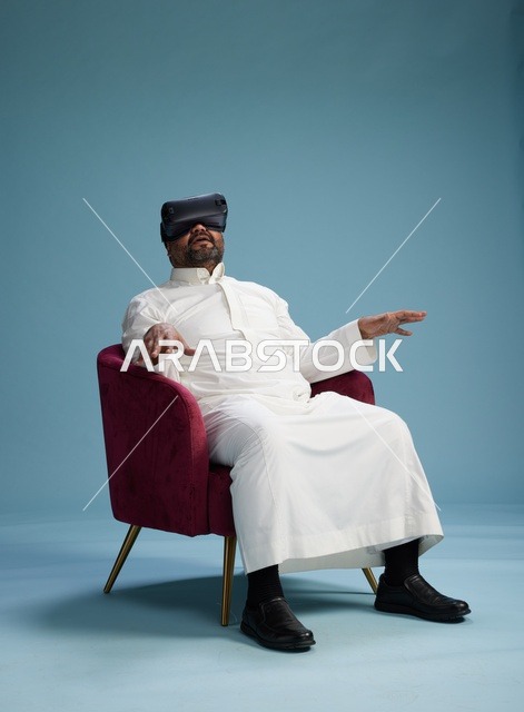 رجل سعودي بالزي التقليدي يخوض تجربة واقع افتراضي, مشاهدة افلام الفي ار, خلفيه زرقاء