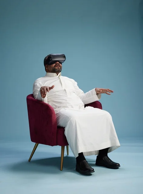 رجل سعودي بالزي التقليدي يخوض تجربة واقع افتراضي, مشاهدة افلام الفي ار, خلفيه زرقاء