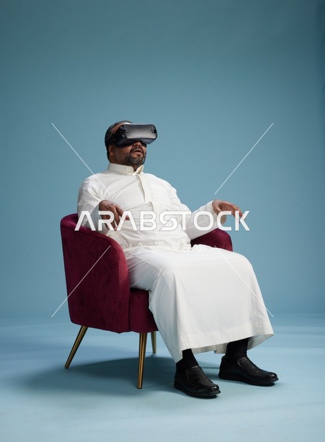 رجل سعودي بالزي التقليدي يخوض تجربة واقع افتراضي, مشاهدة افلام الفي ار, خلفيه زرقاء
