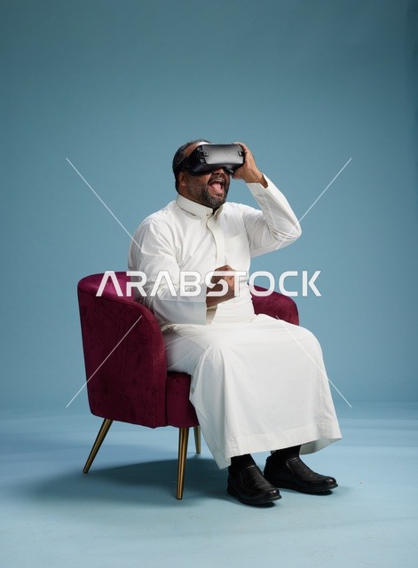 رجل سعودي بالزي التقليدي يخوض تجربة واقع افتراضي, مشاهدة افلام الفي ار, خلفيه زرقاء