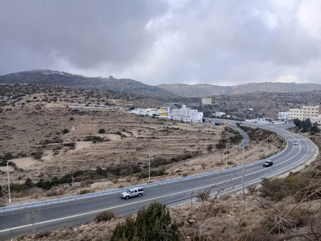 البيوت السكنية والطرقات المهيئة في المدينة، المعالم السياحية التاريخية المشهورة، منطقة الباحة في قرية ذي العين الأثرية جنوب المملكة العربية السعودية، الأشجار والنباتات الخضراء المحيطة بالقرية على المرتفعات والقمم الجبلية