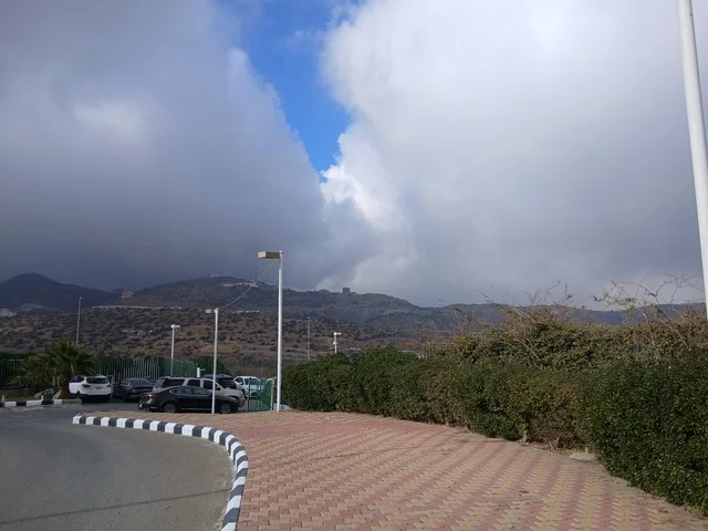 البيوت السكنية والطرقات المهيئة في المدينة، المعالم السياحية التاريخية المشهورة، منطقة الباحة في قرية ذي العين الأثرية جنوب المملكة العربية السعودية، الأشجار والنباتات الخضراء المحيطة بالقرية على المرتفعات والقمم الجبلية