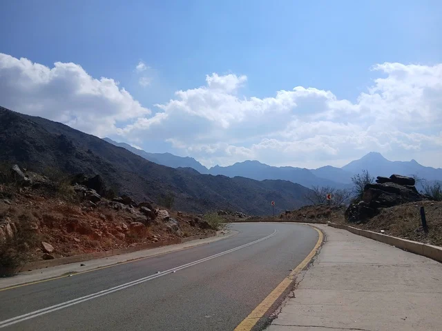 البيوت السكنية والطرقات المهيئة في المدينة، المعالم السياحية التاريخية المشهورة، منطقة الباحة في قرية ذي العين الأثرية جنوب المملكة العربية السعودية، الأشجار والنباتات الخضراء المحيطة بالقرية على المرتفعات والقمم الجبلية