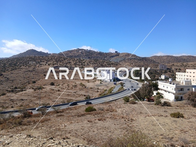 البيوت السكنية والطرقات المهيئة في المدينة، المعالم السياحية التاريخية المشهورة، منطقة الباحة في قرية ذي العين الأثرية جنوب المملكة العربية السعودية، الأشجار والنباتات الخضراء المحيطة بالقرية على المرتفعات والقمم الجبلية