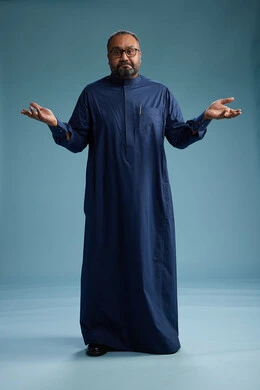 A portrait of a Saudi man standing wearing a navy blue thobe, making various gestures and movements, standing full body, with a blue background.