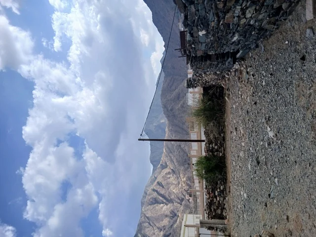 منظر السماء الملبدة بالغيوم في المنطقة الجبلية، المعالم السياحية التاريخية المشهورة، المرتفعات والقمم الجبلية بمنطقة الباحة في قرية ذي العين الأثرية جنوب المملكة العربية السعودية،  البيوت السكنية والطرقات المهيئة في المدينة، الأشجار والنباتات الخضراء