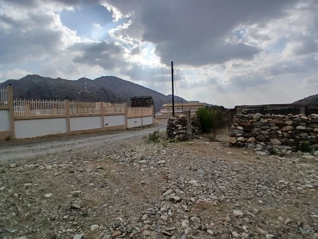 منظر السماء الملبدة بالغيوم في المنطقة الجبلية، المعالم السياحية التاريخية المشهورة، المرتفعات والقمم الجبلية بمنطقة الباحة في قرية ذي العين الأثرية جنوب المملكة العربية السعودية،  البيوت السكنية والطرقات المهيئة في المدينة، الأشجار والنباتات الخضراء