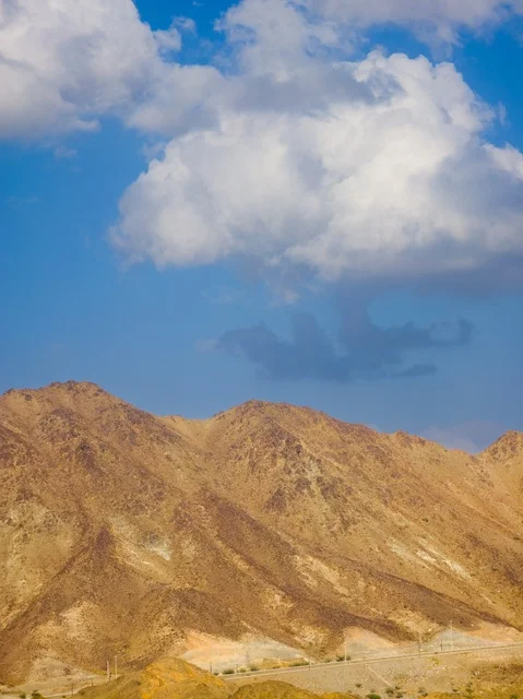 The view of the cloudy sky over the Hatta tourist mountains in the Emirate of Dubai, United Arab Emirates, the mountainous highlands, the backdrop of mountain nature, tourism in the UAE, Hatta Mountains.