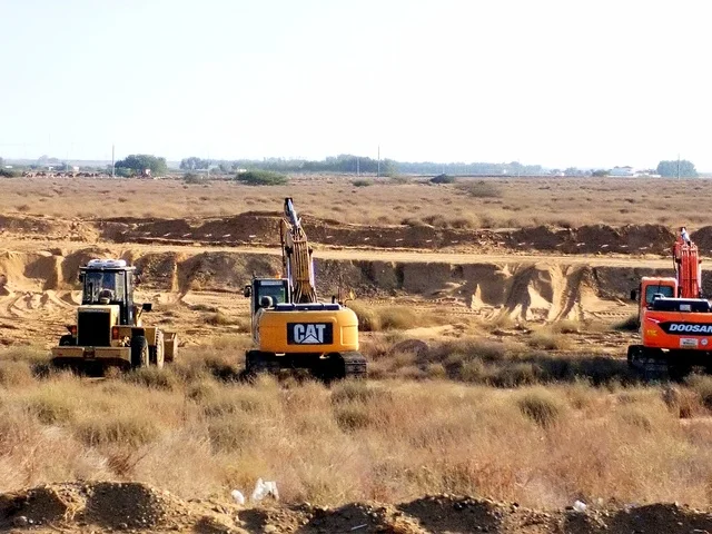 معدات حفر وآليات ثقيلة تعمل في موقع صحراوي، تنفيذ أعمال بنية تحتية وتمهيد أراضٍ، تجهيز مشاريع إنشائية وتنموية، مشهد يعكس التطوير العمراني والصناعي، بيئة عمل مفتوحة في المناطق الصحراوية بالمملكة العربية السعودية