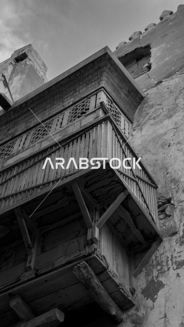 A black and white photo of the historical buildings in the historic district of Jeddah in the Kingdom of Saudi Arabia, the alleys of the historic district in Jeddah, ancient Arab architectural design, archaeological buildings, historical landmarks in Jeddah, tourism in Saudi Arabia.