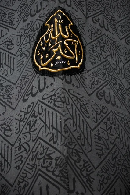 A close-up image of the Kaaba in Mecca, the cover of the Kaaba, Quranic verses on the cover of the Kaaba, the Black Stone, the House of God (Al-Haram) in the holy mosque in Mecca, Saudi Arabia, sacred Islamic places, the entrance to the Kaaba in the Grand Mosque in Mecca.