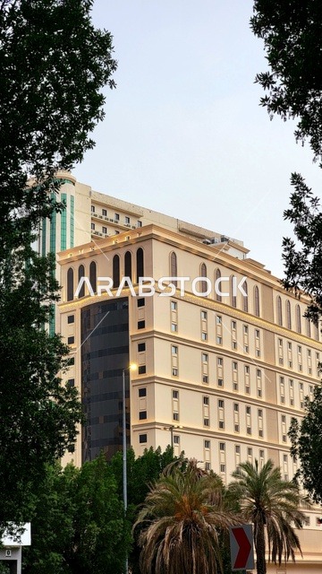 The exterior design of a hotel in the Al-Aziziyah district of Mecca, featuring a modern architectural facade that reflects the urban character of the Kingdom of Saudi Arabia. An elegant hotel building dedicated to welcoming pilgrims and Umrah performers, with contemporary engineering details and comprehensive hospitality services near the holy sites.