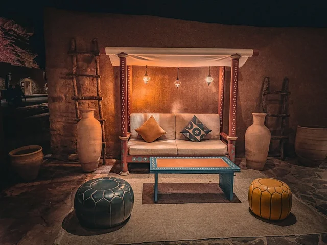 A heritage session in the old town of Al-Ula, Saudi Arabia, featuring traditional decor that reflects the historical character and ancient life, popular furnishings, and pottery. A warm atmosphere inspired by authentic Saudi heritage, a cultural experience that expresses the authenticity of the place and the depth of history.